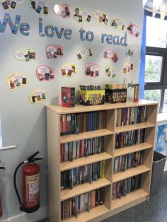 a bookshelf filled with lots of books next to a fire extinguisher