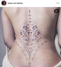 the back of a woman's stomach with an intricate design on her lower back