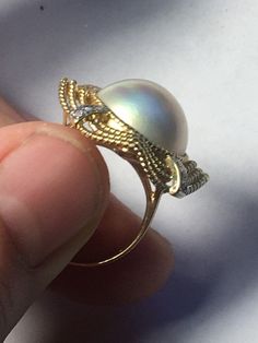 A beautiful Mave Pearl (genuine, cultured) set in 14K gold ring surrounded by diamonds. 4 strips of 3 diamonds each total 12 diamonds. The gold banding has a bend to it in the centers, which isn't necessarily shown the best in the photos. Beautifully made elegant ring great for anyone special Elegant Diamond White Dome Ring For Formal Occasions, Gold Oval Pearl Ring With Prong Setting, Elegant Diamond Dome Ring As Gift, Elegant Oval Pearl Ring With Diamond Accents, Elegant Diamond Dome Ring For Wedding, Yellow Gold Diamond Rings With High Luster, Elegant Dome Ring For Formal Occasions, Elegant Formal Dome Ring, Gold Pearl Ring With Diamond Accents For Anniversary