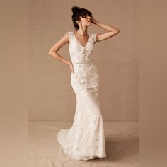 a woman in a wedding dress posing for the camera with her hand on her head