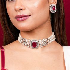 With this Manish Malhotra Jewelry Inspired, You can channel Princess Diana's iconic style with this Ruby Pearl Necklace. Wear a Ruby Choker Necklace to exude regality, or a Red Diamond Necklace to exude opulence. Choose a Pearl Diamond Choker for a touch of class. Inspired by Princess Diana's timeless style, these pieces combine the allure of rubies with the delicate beauty of pearls and diamonds, adding a touch of royal elegance to any ensemble. *𝐏𝐑𝐎𝐃𝐔𝐂𝐓 𝐃𝐄𝐓𝐀𝐈𝐋* * Material: Brass * Plating: White Rhodium Plated * Stone: AAA-quality CZ diamond & Ruby. *𝐃𝐈𝐌𝐄𝐍𝐒𝐈𝐎𝐍𝐒*  Necklace * Weight: 55 gm * Width: 1.15 Inches * Design Length: 10 inches * Total Length with Closure: 14.2 inches  Earrings * Weight: 9 gm each * Length: 1 Inch * Width:  0.9 Inches * Closure: Push Back *? Ruby Diamond Choker, Choker Diamond Necklace, Diamond Ruby Necklace, Red Ruby Necklace, Ruby Choker, Ruby Red Necklace, Modern Classic Wedding, Pearl Diamond Necklace, Ruby And Pearl