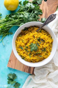 a white bowl filled with yellow rice and cilantro