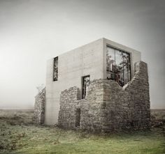 a house made out of bricks sitting on top of a grass covered field