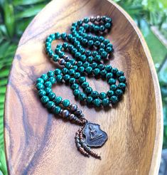 Due to the vintage nature of the amulet featured in this mala, this is a one-of-a-kind piece and will not be recreated  MALACHITE  Resilience, Protection, Change & Transformation Natural, Ethically-sourced Gemstones: 8mm Genuine Malachite Beads, Grade AAA Rare Vintage Copper Buddhist Amulet (1970s), Made in Thailand, Blessed in Bhutan Fair trade raw copper beads, Ethiopia This mala features 108 beads, hand-knotted in traditional style between each bead. The beads are each 8mm in diameter. All of our pieces are knotted on a durable rayon-based cord, a Vegan alternative to silk that significantly enhances the longevity & durability of your mala. 💓 Thank you for supporting our work, and for shopping small. We appreciate you more than words on a screen can express. Spiritual Beaded Malachite Jewelry, Spiritual Malachite Beaded Jewelry, Malachite Jewelry With 8mm Round Beads, Traditional Green Necklace For Meditation, Green Spiritual Beads For Healing, Artisan Chrysocolla Beaded Necklace For Healing, Green Gemstone Beads Mala For Healing, Green Spiritual Beads, 108 Count, Bohemian Malachite Necklaces For Healing