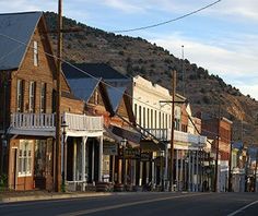 an image of a street with buildings on the side and mountains in the back ground