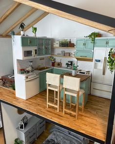 an overhead view of a kitchen and living room in a doll house with furniture on the floor