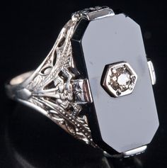 Vintage 1920's 14k White Gold Onyx Diamond Cocktail Style Ring .07ct 3.4gMetal Information: 14k White GoldTotal Weight: 3.4gBand Width: 1.95mmSize: 6.75Circa: 1920'sStone InformationMain StoneGem Type: OnyxShape: Octagon (17mm x 8.5mm)Color: BlackClarity/Quality: AANumber of Stones: 1Accent StonesGem Type: DiamondShape: Old European (2.6mm)Color: JClarity/Quality: SI1Carat Weight: .07ctNumber of Stones: 1Total estimated ctw (carat total weight): .07ctwEstimated Retail Price: $1875.00OUR PRICE: $ Victorian 14k White Gold Formal Jewelry, Victorian 14k White Gold Jewelry For Formal Occasions, Art Deco 14k Gold Evening Jewelry, Art Deco Black Engraved Jewelry, Art Deco 14k White Gold Jewelry, Art Deco 14k Gold Jewelry, Black Art Deco Jewelry Stamped 14k, Black Platinum Wedding Jewelry, Black Platinum Jewelry For Wedding