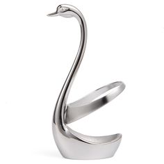 a metal swan sculpture sitting on top of a white surface