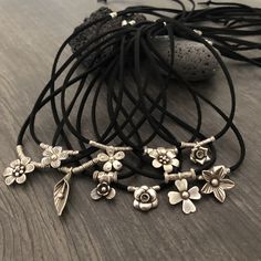 Unique one of a kind silver flower charms choker. 10 different necklaces, made with a long black leather cord and 10 unique silver flower pendants with silver beads. This necklaces can be adjusted to chokers or can be long necklaces like you can see in the picture. Perfect stacking necklaces that will rock your outfit and will be easy to match other accessories. You can see in 2 of the pictures that each flower choker has a number, that way you know which one are choosing. A unique addition to y Handmade Adjustable Charm Necklace, Handmade Adjustable Charm Necklace Choker, Handmade Necklaces With Waxed Cord, Handmade Adjustable Choker Charm Necklace, Handmade Adjustable Charm Choker Necklace, Adjustable Handmade Charm Necklace Choker, Adjustable Flower Pendant Charm Necklace, Flower Pendant Necklace With Adjustable Cord, Adjustable Nickel-free Charm Necklace With Flower Pendant