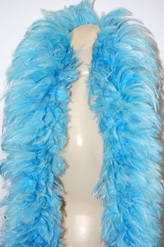 a white mannequin with blue feathers on it