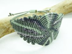 a beaded bracelet sitting on top of a wooden branch