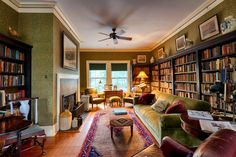 a living room filled with lots of furniture and bookshelves next to a fire place