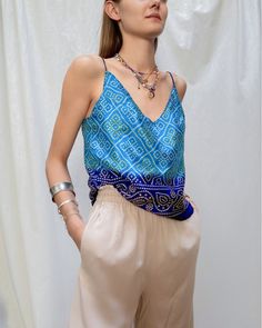 A vibrant electric blue silk top, perfect for the summer. This bohemian top is made from an upcycled saree and features intricate Bandhani print, a traditional Indian technique. The soft silk fabric is lightweight and comfortable, making it perfect for hot summer days. Pair it with denim shorts or a flowy skirt for a chic boho look. Blue Shorts Outfit, Hippie Chic Style, Blue Cami Top, Style Hippie Chic, Hippie Chic Fashion, Strap Blouse, Festival Mode, Silk Cami Top, Blue Cami