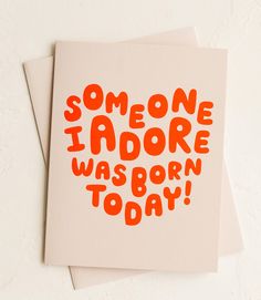 someone i adore was born today greeting card with orange ink on white paper,