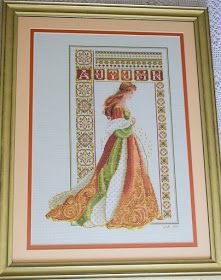 a cross stitch picture of a woman in a dress