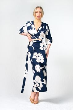 Introducing the Kazu Dress, a captivating design crafted with meticulous attention to detail. Made in a beautiful blue and cream floral print, it features a wrap-around bodice that creates a flattering and adjustable fit, embracing every body type. The straight-line skirt flows effortlessly, lending an air of elegance to your every step, while the bareback design with its arched detailing adds a touch of sensuality. Completing the look, the kimono sleeves provide a hint of relaxed refinement and Elegant Floral Print Maxi Wrap Dress, Elegant Wrap Dress With Floral Print And Surplice Neckline, Elegant Floral Wrap Dress With Surplice Neckline, V-neck Floral Print Wrap Dress For Evening, Fitted Floral Print Maxi Wrap Dress, Fitted Floral Print Maxi Length Wrap Dress, Floral Print V-neck Evening Wrap Dress, Elegant Floral Print Wrap Dress, Blue Floral Print Wrap Dress