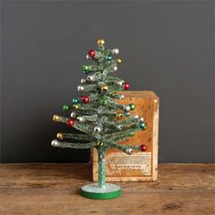 a small christmas tree sitting on top of a wooden table