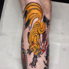 a man's leg with tattoos on it and an orange bird flying over his head