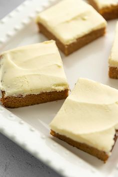 four pieces of cake on a plate with white frosting and one slice is missing