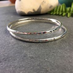 These sterling silver bangles are handmade by me, in my little studio. The chunky bangles are made from 3mm D shape sterling silver, and finished with a hammered texture which reflects the light. They have been given a slightly oval shape, to fit the wrist more comfortably. Each silver bracelet is hallmarked by the London Assay Office for quality. They layer up nicely as a stacking bangles. If you would like a larger set, or different size, please convo me directly. Choose from: Small/Med - approx 62x57mm Med/Large - approx 67x61mm The bangle will be packaged in a branded gift box ready for gifting. This listing is for one bangle. -Returns/exchanges on made to order rings- I will happily accept returns or exchanges within 14 days. -Delivery- Your silver bangle is ready to be shipped! Simple Bangles, Stacking Bangles, Hammered Bangles, Turquoise Gold Ring, Simple Bangle, Bangle Silver, Sterling Silver Stacking Rings, Sterling Silver Bangle, Silver Stacking Rings