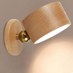 a wall light with a wooden shade on it