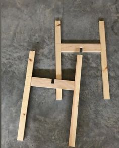 two pieces of wood sitting on top of a cement floor with one piece missing from the frame