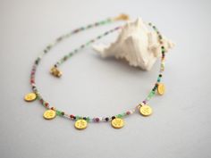 Add a pop of color to your summer wardrobe with this stunning Rainbow Gold Coin Necklace! This unique piece features a colorful array of beads in vibrant hues, perfect for adding a playful touch to any outfit. The delicate gold coin pendant adds a touch of elegance, making this necklace the perfect accessory for summer parties, beach days, or festivals. Stand out and shine bright with this one-of-a-kind necklace that is sure to make a statement wherever you go! Technical Details * Metal: gold pl Handmade Multicolor Strand Jewelry, Handmade Colorful Beads For Beach, Multicolor Strand Necklace For Gift, Multicolor Beaded Strand Necklace For Gift, Multicolor Strand Necklace As Gift, Multicolor Strand Jewelry For Gifts, Multicolor Strand Jewelry As Gift, Multicolor Strand Jewelry As A Gift, Multicolor Gemstone Beads Jewelry For Beach