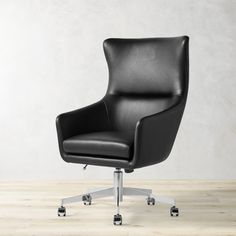 a black office chair sitting on top of a hard wood floor next to a white wall