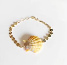 Beachy shells bracelet is make with natural color sunrise shell and gold filled disc chain. 14k gold filled 4.1 mm round disc chain. Hawaiian sunrise shells are nickel size (3/4 inch). Shells 's colors are vary due to availability. PLEASE NOTE: this is stock photos so the bracelet you receive will be very similar and just as beautiful. Don't hesitate to contact me for picture of shells available. Sunrise shells are an extremely rare and sacred shell, containing every color of the spectrum, but u Gold Shell Beaded Bracelets As Gift, Adjustable Gold Beaded Shell Bracelets, Adjustable Gold Shell, Gold Shell Bracelets For Gifts, Gold Shell Bracelets For Gift, Handmade Gold Shell-shaped Bracelets, Handmade Gold Shell Bracelets, Handmade Gold Shell-shaped Bracelet, Gold Mother Of Pearl Shell