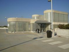 an empty parking lot in front of a large building with glass blocks on the side