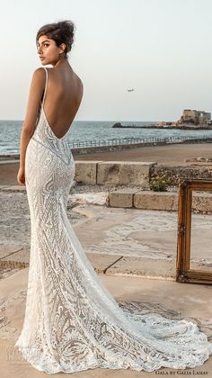 a woman in a wedding dress looking at the ocean