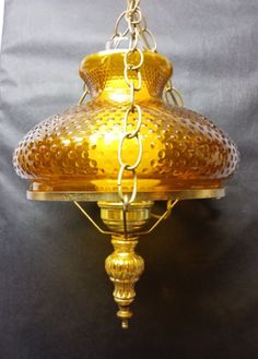 a gold colored lamp hanging from the ceiling