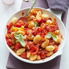 a white bowl filled with pasta and tomatoes