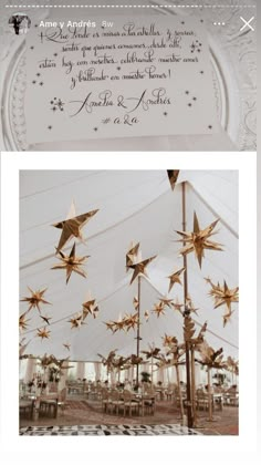 an image of stars hanging from the ceiling in front of a white tent with writing on it