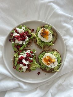 an open face sandwich with avocado, pomegranate and eggs on it