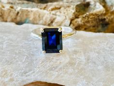 This classic 4 prong setting contains a beautiful 4.00ct. lab created emerald cut sapphire. The stone measures approximately 10x8mm. The ring is available in sterling silver, and 14k white, yellow, or rose gold. This ring makes a great promise or engagement ring. Please send me a message if you need a size not listed. All items are handmade by me in my shop in Woodbridge, NJ. Please message me with any questions. Shipping within the United States is complimentary. Thank you for exploring my shop Classic Radiant Cut Sapphire Ring, Classic Sapphire Ring With Rectangular Stone, Emerald Cut Solitaire Sapphire Ring, Classic Sapphire Ring With Rectangular Stone And Prong Setting, Classic Sapphire Ring With Prong Setting And Rectangular Stone, Sapphire Solitaire Ring With Radiant Cut, Radiant Cut Solitaire Sapphire Ring As Gift, Emerald Cut Sapphire Ring Gift, Emerald Cut Sapphire Ring Vs Clarity