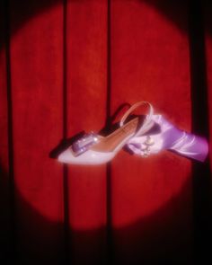 a pair of shoes sitting on top of a wooden floor next to a red wall