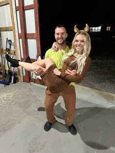 a man and woman dressed in costumes posing for the camera with their arms around each other