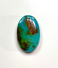 a piece of turquoise colored stone sitting on top of a white table