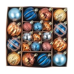 a box filled with assorted christmas ornaments on top of a white background, including blue and gold baubles