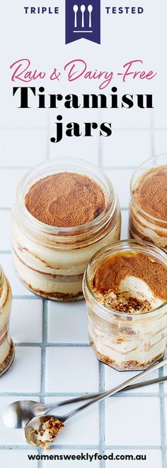 three jars filled with dessert sitting on top of a white tiled floor next to spoons