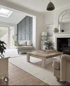 a living room filled with furniture and a fire place under a skylight in front of a window