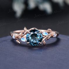 an oval blue topaz ring with leaves on the sides and diamonds in the middle