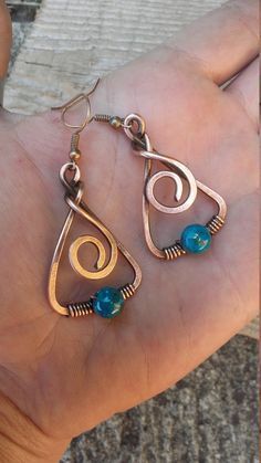 a person is holding some kind of earring in their hand and it has two different designs on it