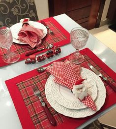 the table is set with red and white plaid placemats, silverware, and napkins