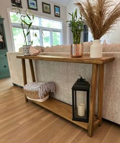 a wooden table sitting on top of a hard wood floor next to a white couch