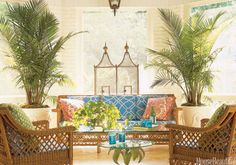 a living room with wicker furniture and potted plants