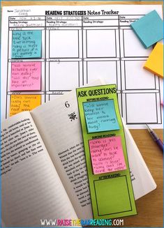 an open book with sticky notes attached to it next to a pen and pencil on a table