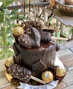 a birthday cake with chocolate frosting and gold decorations