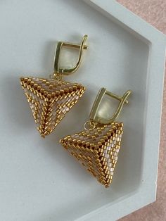 two pairs of earrings sitting on top of a white tray